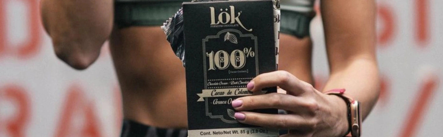 Person holding a black box with 'Lök' branding and '100%' text.