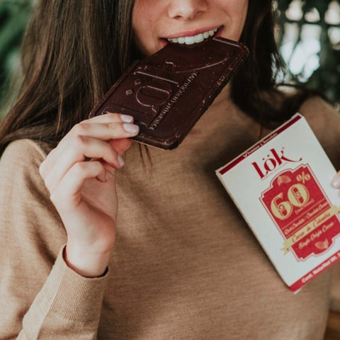 Woman holding a large chocolate bar and a box of Lök 60% chocolate.