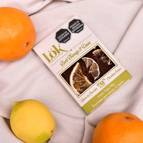 Chocolate bar with orange and lemon slices on a light fabric background