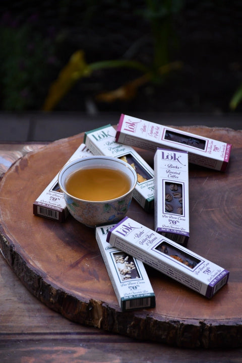 Tea packaging and a cup of tea on a wooden surface with a blurred natural background