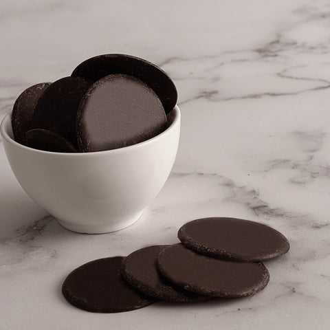 Dark chocolate cookies in a white bowl on a marble surface
